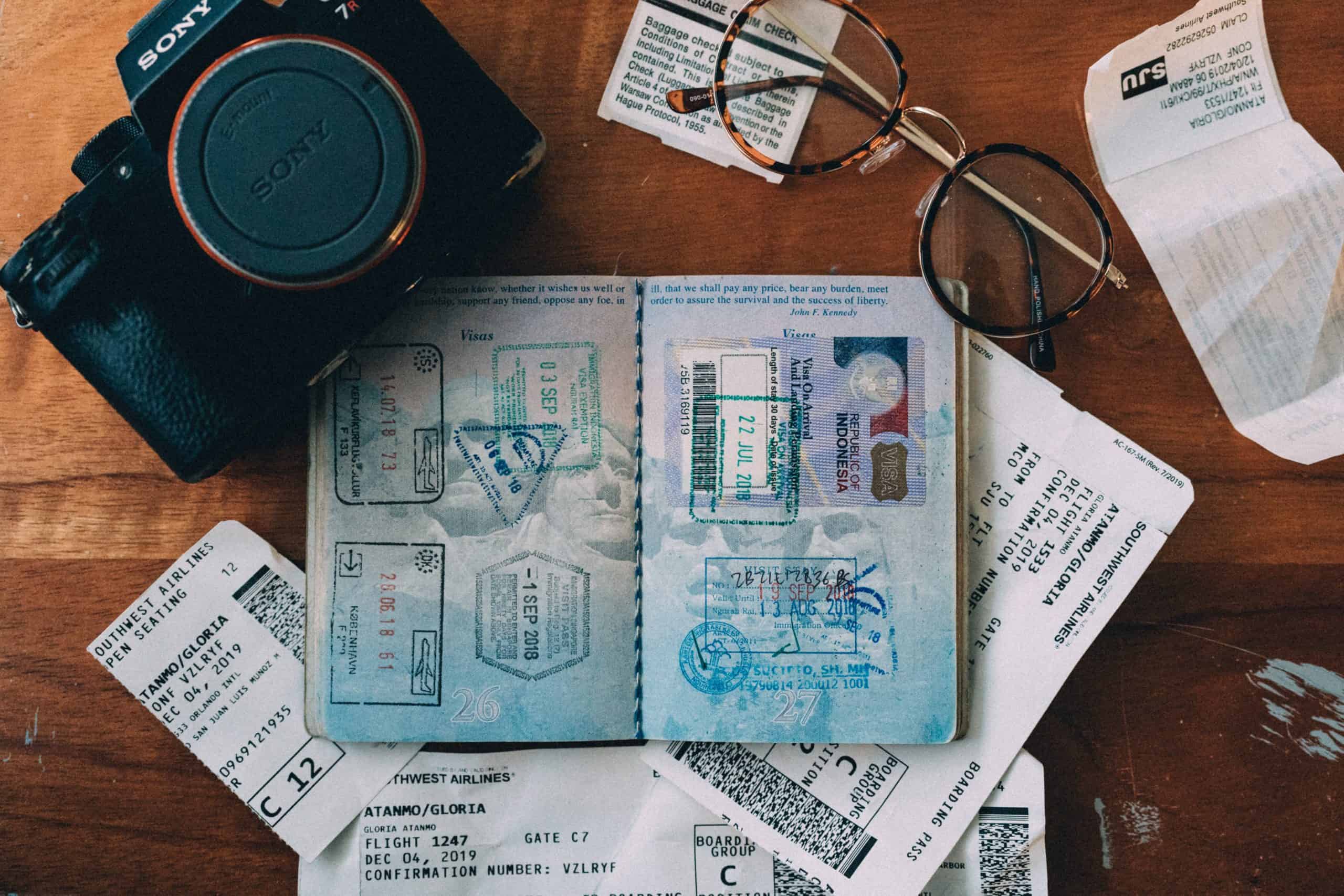 passport, camera and travel documents on a desk